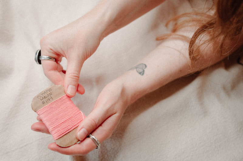 pink embroidery thread and hands, brand photography by North Shore photographer Kayla Schiltgen